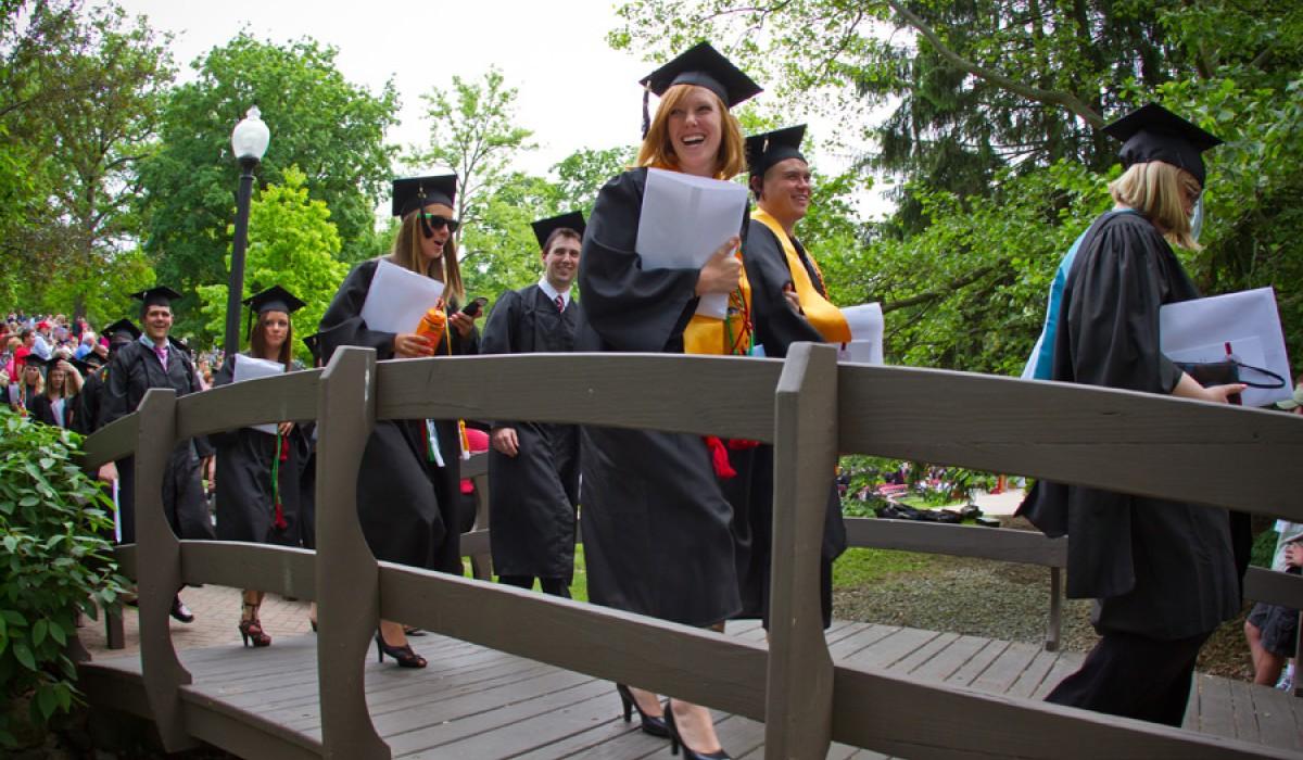 Graduate walking across Kissing Bridge